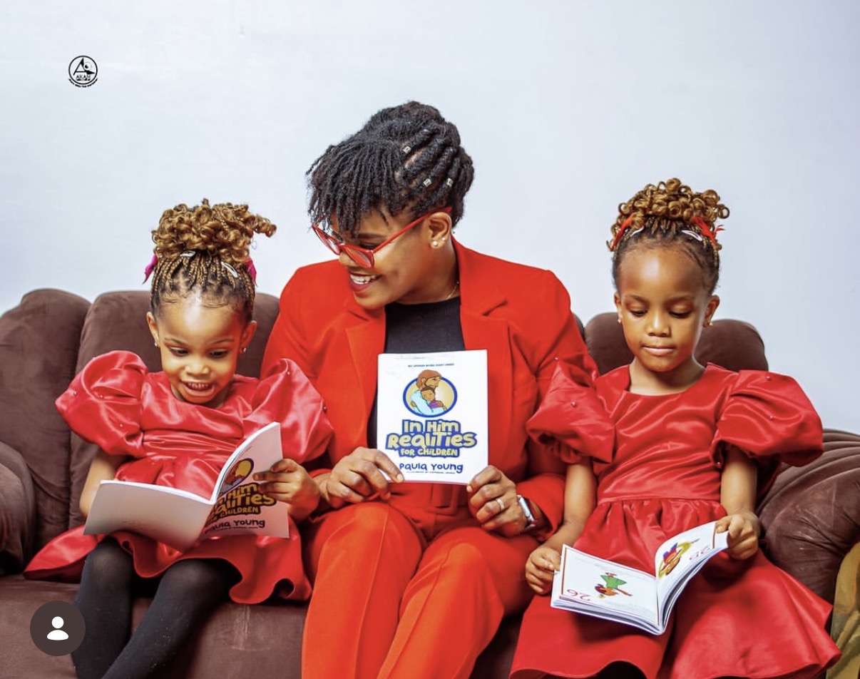 Paula Young reading In Him Realities for Children with two young readers
